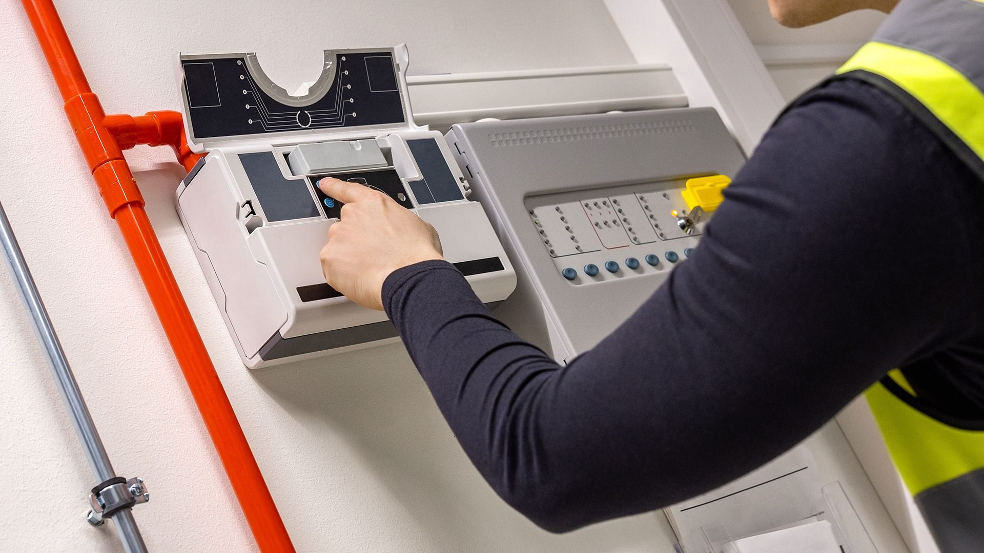 Male Ttechnician checking smoke detector in dealership