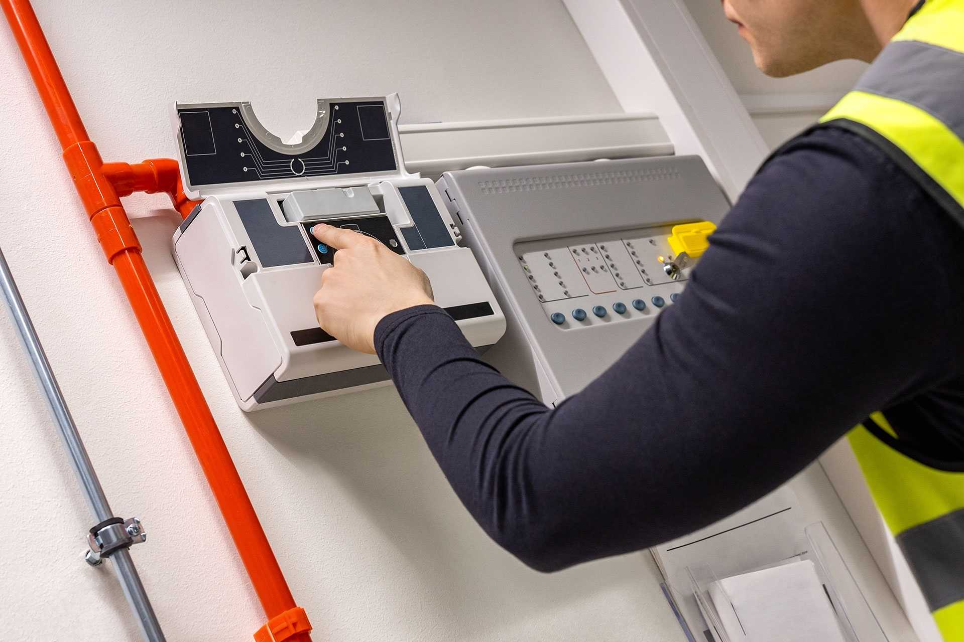 Male Ttechnician checking smoke detector in dealership