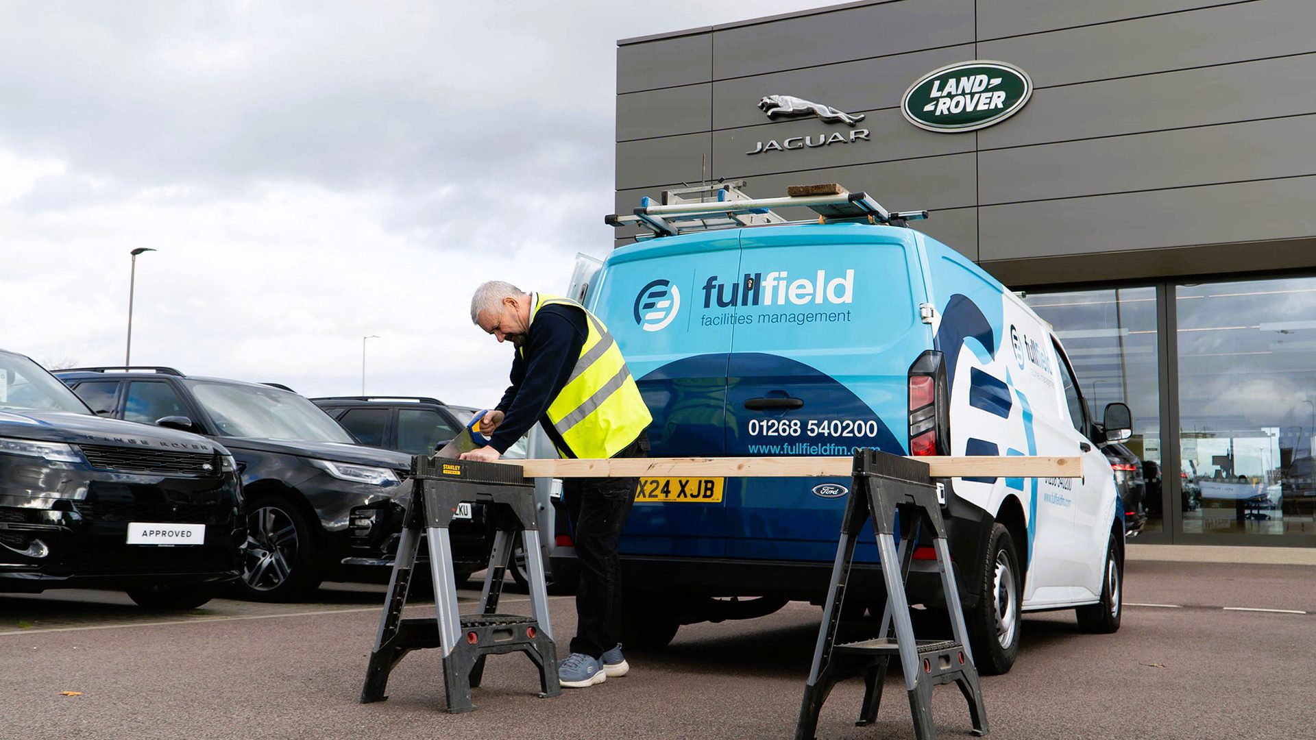 Fullfield maintenance worker sawing wood