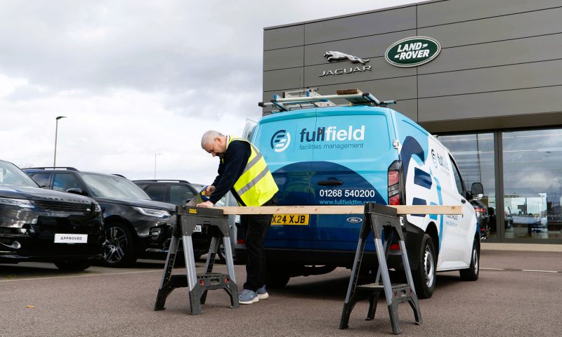 Fullfield maintenance worker sawing wood