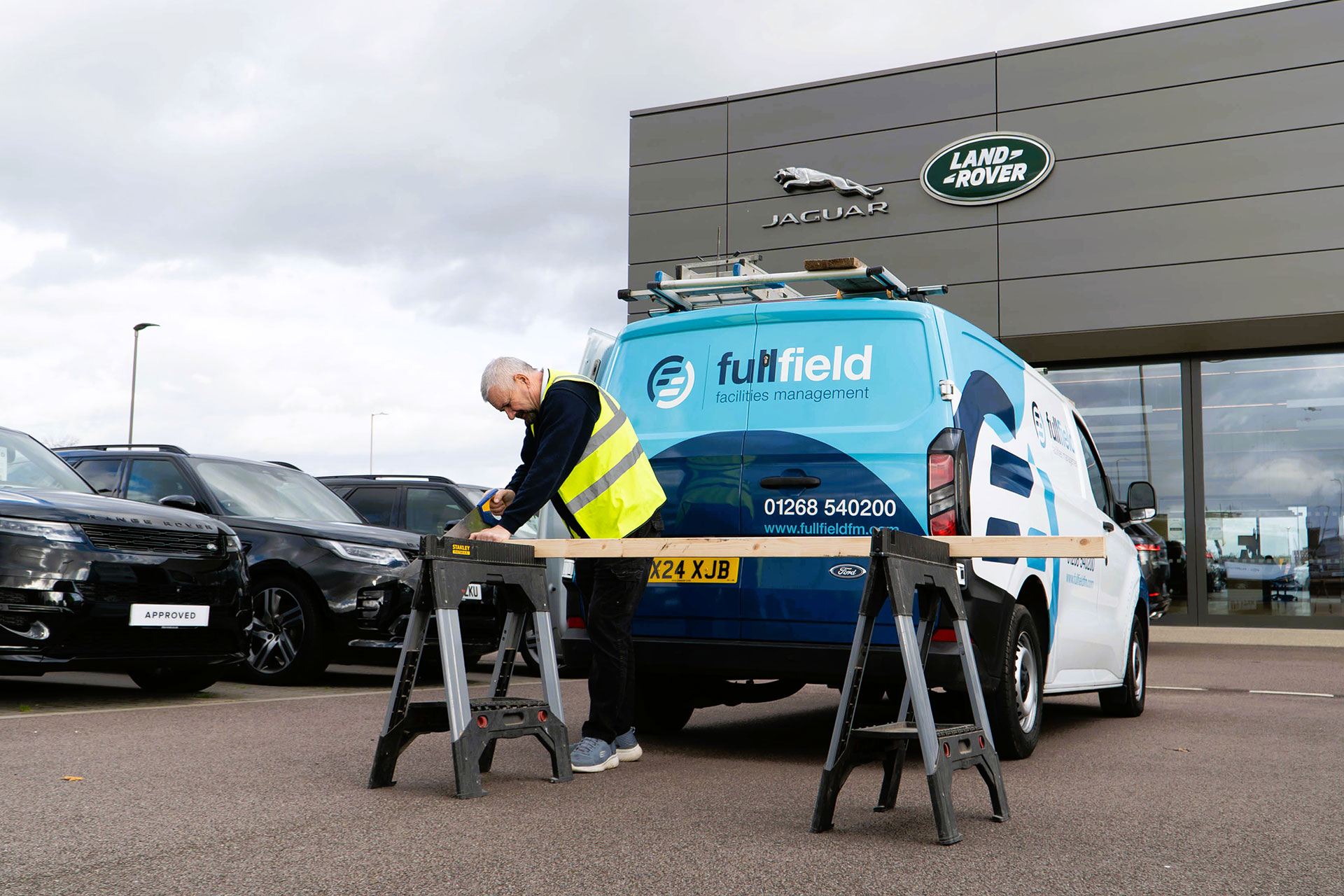 Fullfield maintenance worker sawing wood